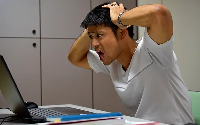 ウイルスによって起動しなくなって困る男性